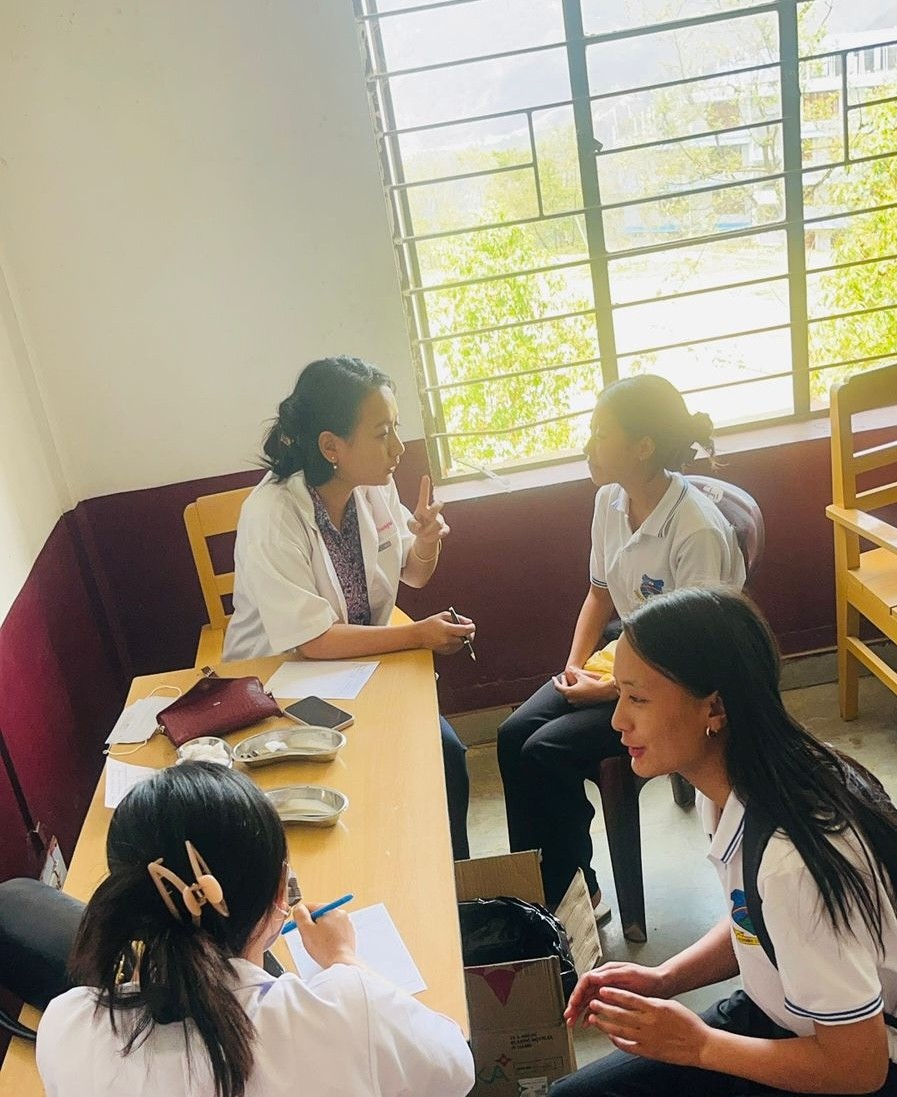 A dental doctor from NHAK providing an oral check-up to a student.